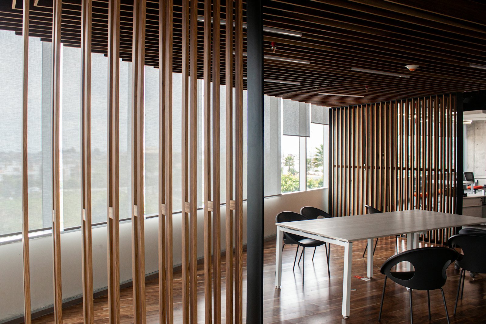 Roller shades in a meeting room with timber screens