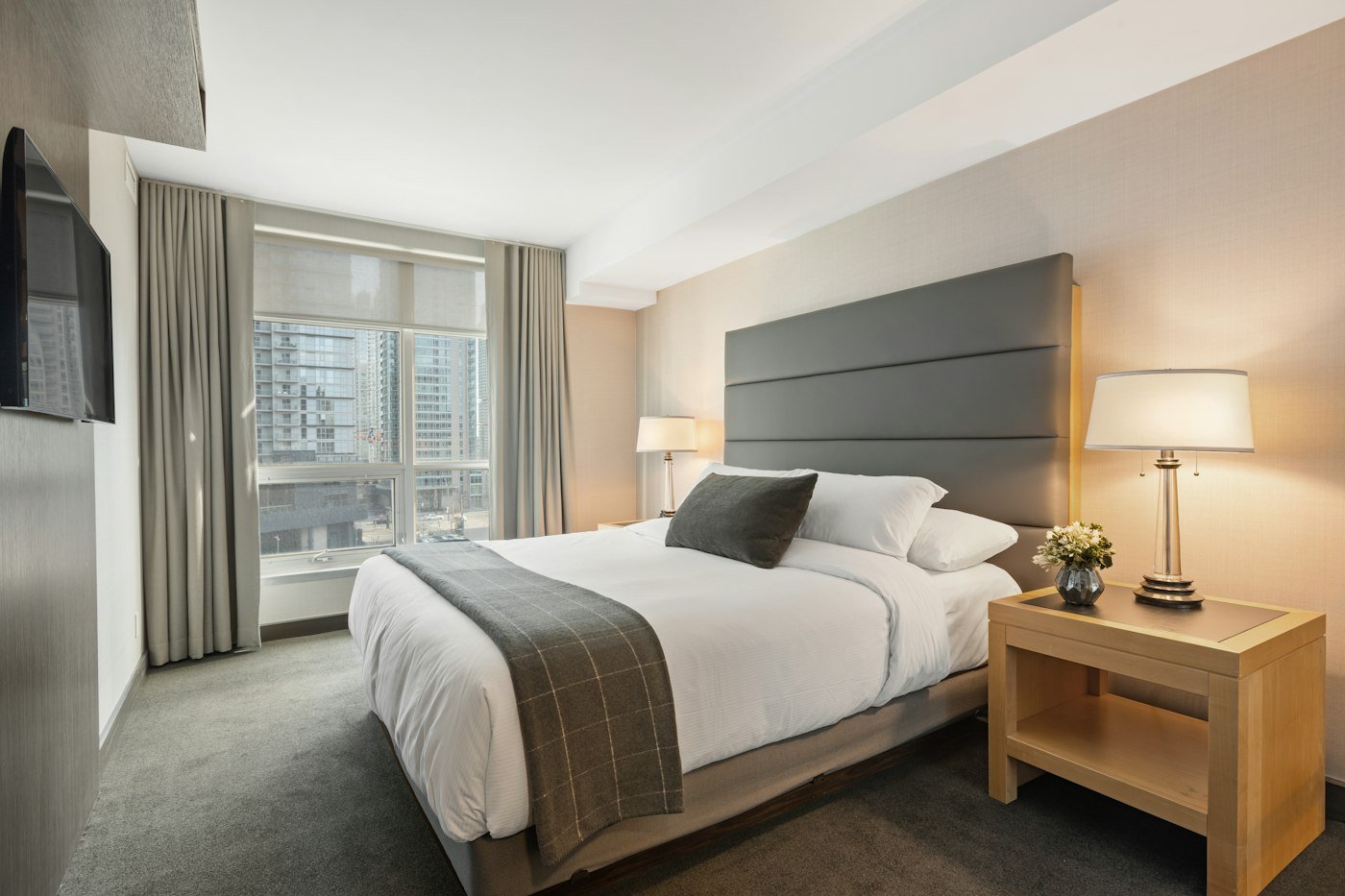 Grey curtains framing a hotel bedroom window