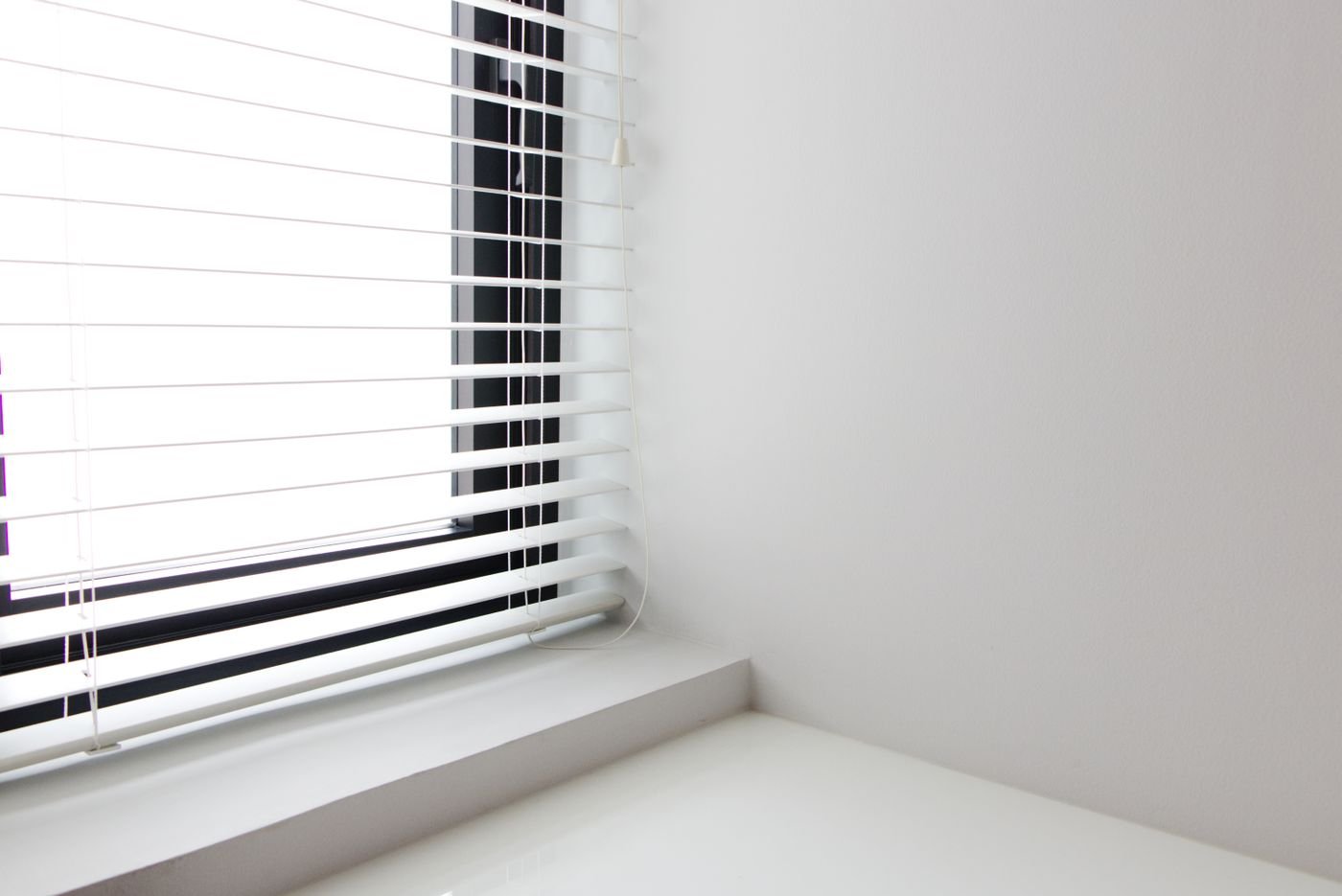 White venetian blinds close to the glass