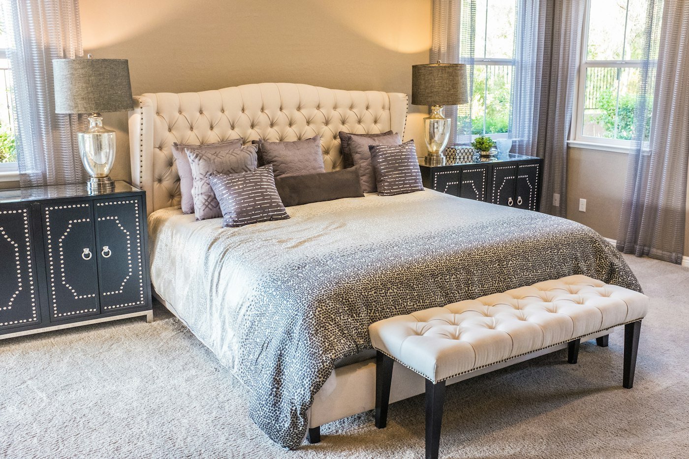 Sheer curtains on both sides of a bedroom, with carpet under the bed