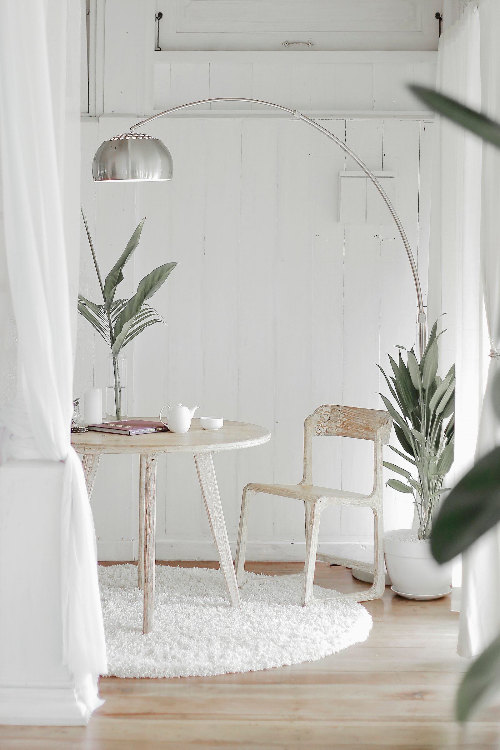 Sheer white curtains framing a sitting corner
